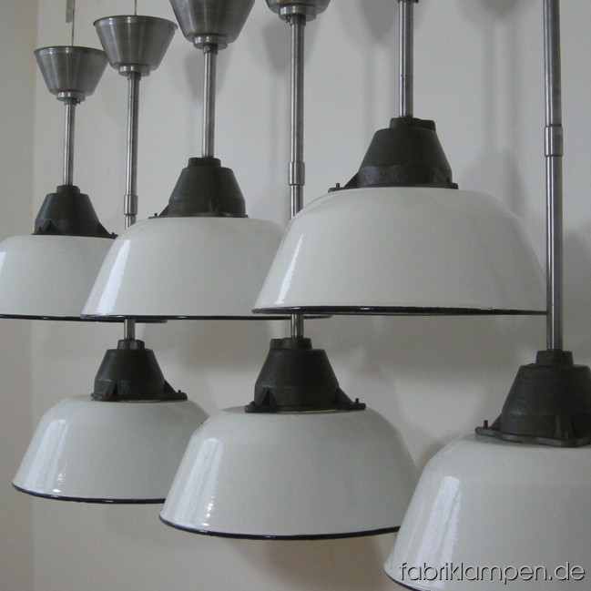 Industrial lamps with white enameled shades. Material: enameled sheet and casted iron, with iron suspension. Total height: as on the pictures: 74 cm (29,1 inches), with one steel tube 46,5 cm (18,3 inches). With another steel tube of 25 cm (9,8 inches) the total height can be increase up to 99 cm (39 inches). Height lamp ca. 23 cm (9 inches), diameter of the lamp ca. 36 cm (14,2 inches). 28 pieces available.
