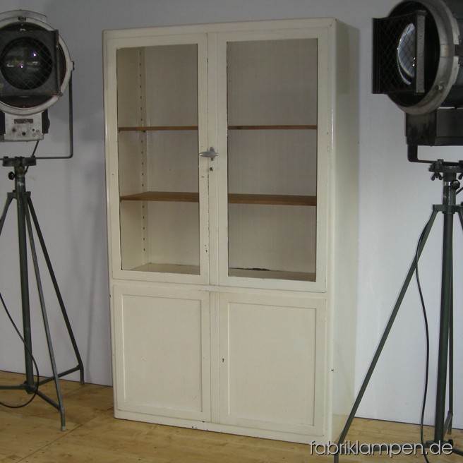 Alter Artschrank oder Arztvitrine (Baisch ?) um etwa 1950-1960 im Originalzustand. Mit Holzregalböden und starken Gebrauchsspuren (Patina, siehe Bilder). Die Lackierung ist stellenweise (z. B. an Rändern der Schubläden oder an Ecken/Rändern) stark beschädigt. Ohne Schlüsseln. Breite ca. 100 cm, Höhe ca. 170 cm, Tiefe ca. 41 cm.