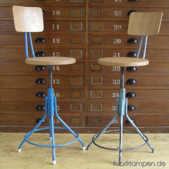 2 Stück alte Drehstühle (Industriestühle o. Werkstattstühle) um etwa 1950 als Paar (mit Farbenunterschied). Die Gestelle sind im guten Originalzustand, mit üblichen Gebrauchsspuren, Sitze und Kopflehnen sind erneuert (Sperrholz, gewachst) worden. Wegen Sitzhöhe können die Stühle auch als Barhocker gebraucht werden. Sitzhöhe ca. 53-67 cm, Durchmesser Sitze ca. 35 cm.