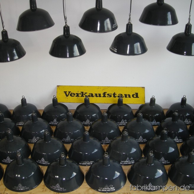 Graue Emaille Industrielampen mit Aufschrift im schönen Originalzustand. Material: grau (bläulich) emailliertes Blech, mit Drahtseil-Aufhängung. Die Lampen sind gereinigt, neu elektrifiziert und getestet – alle Lampen haben eine E27 Fassung, also Sie können sie mit normalen E27 Glühbirnen benutzen. Höhe der Lampen ohne Aufhängeöse ca. 26 cm, Durchmesser Schirm ca. 35 cm. Die Lampen haben ein Schutzgitter mit Schutzglas (s. letzte Bilder). Wir haben diese Lampen auch in anderen Größen auf Lager.