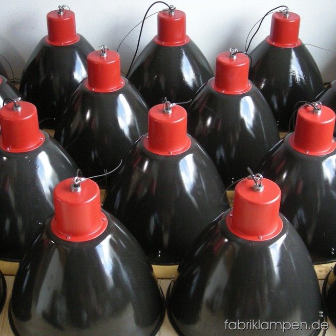 Impressive industrial lamps in black and red. Material: black enameled sheet and red painted top, with wire rope suspension. The lamps are cleaned and newly electrified, with E27 sockets. Total height: ca. 49 cm (19,3 inches). Diameter of the shade ca. 53 cm (21 inches). Made for customer’s order, orderable.