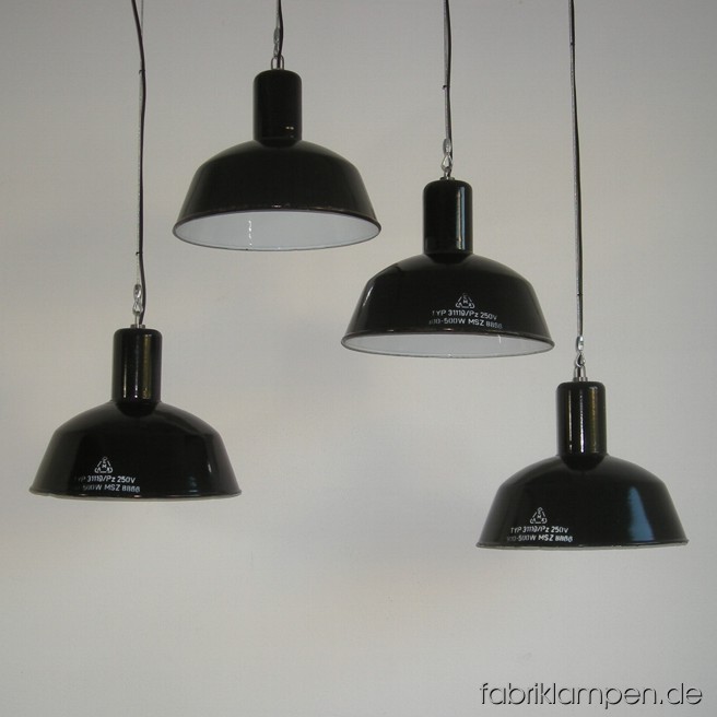 Black industrial lamps with enameled shades. Material: black enameled sheet. Newly electrified, with wire-rope suspension. Height of the lamps ca. 32 cm (12,6 inches), diameter of the shades ca. 41 cm (16,1 inches).