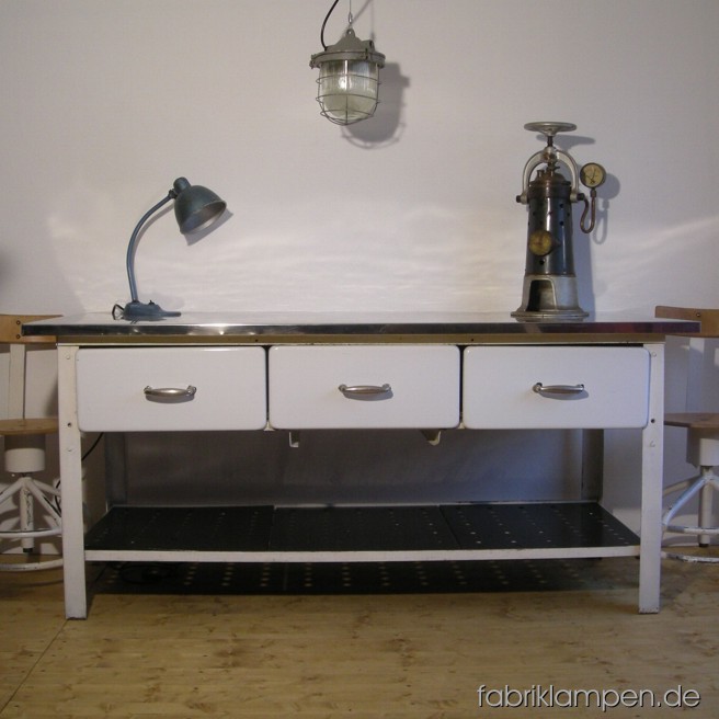 Alter Industrietisch aus einer alten Bäckerei. Weiß lackiertes Metallgestell, weiß emaillierte Schubläden (innen weiß gestrichen) mit vernickelten Metallgriffen, Platte (Sperrholz) mit Edelstahlblech überzogen, unten gelöchertes Ablageregal. Als Tisch in Ihrer Küche oder als Kücheninsel könnte dieses schönes Stück weiterleben. Höhe 86, Platte 189 x 80 cm.