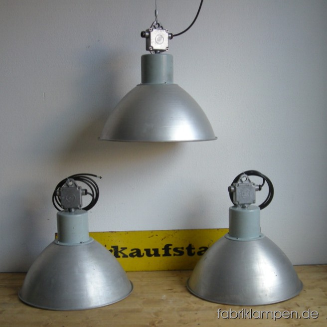 Große Aluminium Fabriklampe im schönen Originalzustand, mit genreüblichen Gebrauchsspuren (Kratzer, kleine Dellen, Farbreste). Nur drei Stück auf Lager. Die Lampen sind neu elektrifiziert und ausgestattet mit originalen E40 Porzellenfassungen und Adaptern von E40 auf E27. Material: Aliminiumblech, hellgrau lackiertes Oberteil. Höhe der Lampen ca. 50 cm, Durchmesser Schirm ca. 51 cm.
