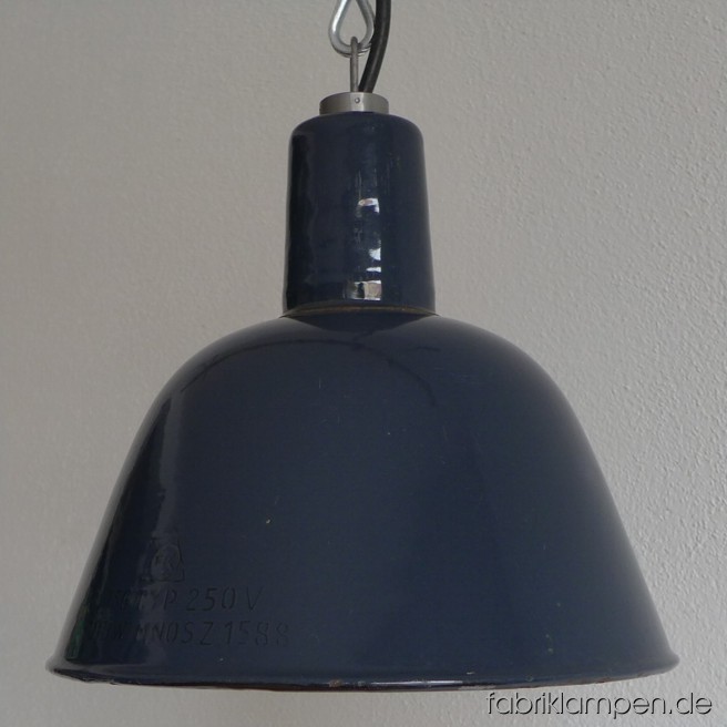 Kleine grau-blaue Industrieleuchte mit schwarzem Aufschrift. Seltene, hohe Form mit schlankem Hals. Material: blau-gräulich emaillertes Blech. Die Lampe ist perfekt erhalten, gereinigt, neu elektrifiziert und mit Drahtseil-Aufhängung ausgestattet. Sie hat eine E27-Fassung und ist daher mit allen gängigen Leuchtmitteln einsatzbar (incl. LED- und Energiespar-Birnen). Höhe der Lampe ca. 23 cm, Durchmesser ca. 26 cm. Die Lampe kann auf Wunsch mit Stahlrohr-Aufhängung und Baldachin geliefert werden (Aufpreis: 20 EUR). 