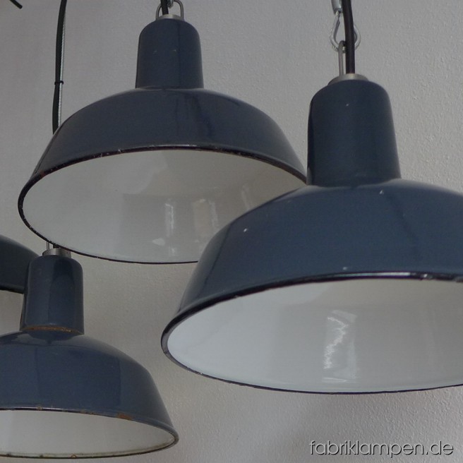 Seltene kleine Industrieleuchten mit schwarzem Aufschrift. Material: grau-bläulich emaillertes Blech. Die Lampen sind schön erhalten, gereinigt, neu elektrifiziert und mit Drahtseil-Aufhängung ausgestattet. Sie haben E27-Fassungen und sind mit allen gängigen Leuchtmitteln einsatzbar (incl. LED- und Energiespar-Birnen). Höhe ca. 18 cm, Durchmesser ca. 26 cm. Die Lampen können auf Wunsch mit Stahlrohr-Aufhängung und Baldachin geliefert werden (Aufpreis: 20 EUR).