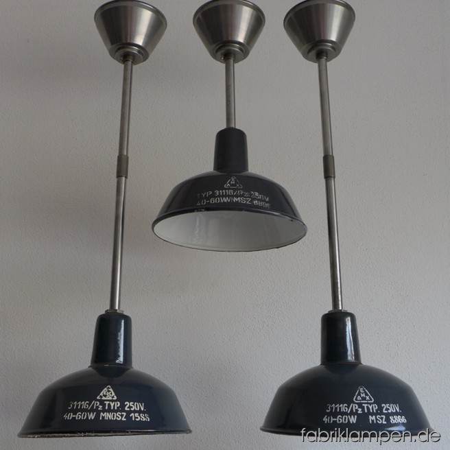 Seltene kleine Industrieleuchten mit schönem Aufschrift. Material: grau-bläulich emaillertes Blech, Stahlrohr-Aufhängung mit Baldachin. Die Lampen sind sehr gut erhalten, gereinigt und neu elektrifiziert. Sie haben E27-Porzellanfassungen und sind mit allen gängigen Leuchtmitteln einsatzbar (incl. LED- und Energiespar-Birnen). Höhe der Lampen ca. 18 cm, Durchmesser ca. 26 cm, Gesamthöhe von 45 bis 74 cm (wie Sie es haben möchten).