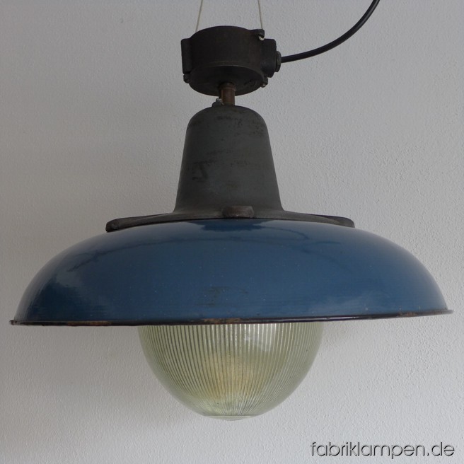 Sehr massive und schwere große blaue Emaille Lampe. Diese Lampe ist DER Hammer: der Schirm hat einen Durchmesser von 52 cm, mit massiven gusseisernem Oberteil und Glaskolben wiegt die Lampe stolze 15 kg. Sie ist die größte ihrer Art und extrem selten zu finden. Nur für Fortgeschrittene mit genügender Innenhöhe und massiver Decke! Die Lampe kann in zwei Ausführungen geliefert werden: entweder mit der originalen Verteilerdose (Gusseisen) oder mit Stahlrohr-Aufhängung. In dem ersten Fall (Verteilerdose) hat die Lampe eine Gesamthöhe von 45 cm und kann mit Hilfe der Löcher in der Verteilerdose aufgehängt oder mit Schrauben direkt in die Decke befestigt werden. Mit Rohr und Baldachin hat sie eine Gesamthöhe von 52 cm (die 25-cm-weise kann verlängert werden) und ist einfach aufzuhängen. Maße: Durchmesser 52 cm, Höhe 46 cm (Verteilerdose) oder 52 cm (Aufhängung mit Rohr), Gewicht 15 Kg. Sie ist natürlich neu elektrifiziert.