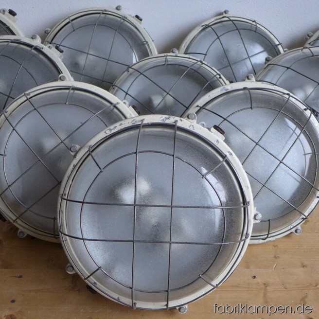 Große, seltene Aluminium Gitterlampen für die Wand oder Decke. Material: beige lackiertes Aluminium-Gehäuse, Thermoglas, Stahlgitter. Die Lampen haben die Spuren der vergangenen Jarhzehnten, sie sind gereinigt und neu elektrifiziert. Die Gitter sind leicht deformiert, die Gläser haben herstellungsbedingte Strukturen (diese sind keine Risse, s. letztes Bild). Die Leuchten haben je zwei E27-Fassungen und sind mit allen gängigen Leuchtmitteln einsatzbar (incl. LED- und Energiespar-Birnen). Die Maßen: Durchmesser ca. 39 cm, Höhe ca. 16 cm.