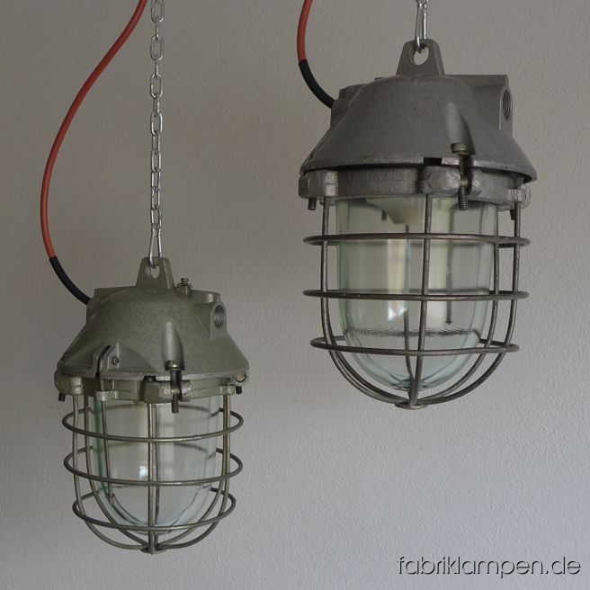 Seltene kleine Aluminium Bunkerlampe mit Schutzglas und Gitter. Aktuell haben wir 15 Exemplare von dem Typ auf Lager, in zwei originalen Farbvarianten: hellgrün oder hellgrau (Aluminiumfarbiger Hammerschlaglack). Die Lampen haben die Spuren der vergangenen Jarhzehnte, sie sind gereinigt und neu elektrifiziert. Material: hellgrün oder hellgrau lackiertes Gehäuse aus Aluminium, Schutzgitter, Schutzglas. Höhe der Lampen ca. 35 cm, Durchmesser ca. 20 cm. Sie bekommen die Lampen mit 2 Meter Kabel, ohne Aufhängung – Kettenaufhängung kann gegen Aufpreis mitgeliefert werden.