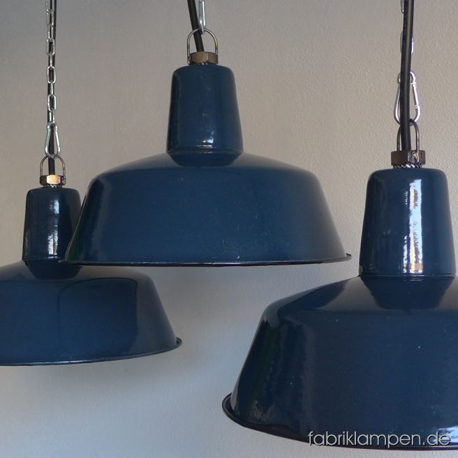 Alte, seltene, blaue Emaille Industrielampen. Die Leuchten haben einen sehr schönen Blauton, wir haben auch einige hellere Exemplare auf Lager. Material: aussen blau, innen weiss emaillertes Blech. Die Lampen haben die Spuren der vergangenen Jarhzehnte (Verfärbungen innen und außen, Abplatzer, Roststellen etc.) wie es auch sein soll. Sie sind gereinigt und neu elektrifiziert. Die Lampen haben E27-Fassungen und sind mit allen gängigen Leuchtmitteln einsetzbar (inkl. LED- und Energiespar-Birnen). Die Maßen: Höhe ca. 21 cm, Durchmesser ca. 32 cm. Diese Lampen sind damals in drei Abmessungen hergestellt worden (Durchmesser 25, 32 und 41 cm) – wir haben derzeit alle drei Größen auf Lager. Rare old blue enamel industrial lamps in a very nice shade of clolour. We have some pale blue lamps of this type too. The lamps have the slight traces of usage and age. Material: blue (inside white) enameled sheet. Cleaned, newly electrified, with E27 ceramic bulbs. Height of the lamp is ca. 21 cm (8,3 inches), diameter of the shade is ca. 33 cm (13 inches). We have also the smaller version of these lampe (diameter 25 cm – 9,8 inches) in stock.
