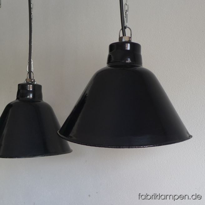 Seltene alte schwarze Industrielampe, Hersteller LBL, VEB Leuchtenbau Leipzig, markiert, Nachkriegszeit. Die Fabriklampen sind asymmetrisch und oval gedrückt: die Form ist elegant, wirkt leicht und ist sehr praktisch z.B. über einem langen Tisch, Sideboard oder einer Theke. Es handelt sich um eine Form-Variante dieser Lampen, diese Lampen sind nich so stark gedrückt. Die Lampen haben die Spuren der vergangenen Jahrzehnte (kleine Abplatzer, Roststellen, Kratzer, Verfärbungen and Co. – wir haben die alle behandelt). Die Leuchten sind gereinigt und neu elektrifiziert, mit E27 Keramikfassung. Material: schwarz (innen weiß) emailliertes Stahlblech. Die Industrielampen werden mit Aufhängeöse und 2 Meter Kabel geliefert (andere Längen sind natürlich möglich), auf Wunsch können sie auch mit Textilkabel und Ketten- oder Stahlrohr-Aufhängung ausgestattet werden (gegen Aufpreis). 
Die Abmessungen: Höhe der Lampe (Schirm) ca. 25 cm, Länge ca. 35 cm, Tiefe (Breite) ca. 30 cm. 