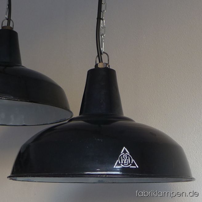 Alte schwarze Fabriklampen als Paar. Material: schwarz (innen weiß) emailliertes Stahlblech mit Herstellermarke. Die Markierung ist schön erhaben. Seltenes Vorkriegsmodell, die Lampen können als antik bezeichnet werden – als Paar ist so was heutzutage kaum zu finden. 
Diese alten Industrielampen haben die üblichen Spuren der vergangenen Jahrzehnte (Abplatzer, Roststellen, Kratzer, Verfärbungen und Co.). Sie sind gereinigt und neu elektrifiziert, mit E27 Keramikfassung. 
Die Fabriklampen werden mit Aufhängeöse und 2 Meter Kabel geliefert (andere Längen sind natürlich möglich), auf Wunsch können sie auch mit Textilkabel und Ketten- oder Stahlrohr-Aufhängung ausgestattet werden (gegen Aufpreis). Die Abmessungen: Durchmesser Lampe (Schirm) 40 cm, Höhe 24,5 cm. 