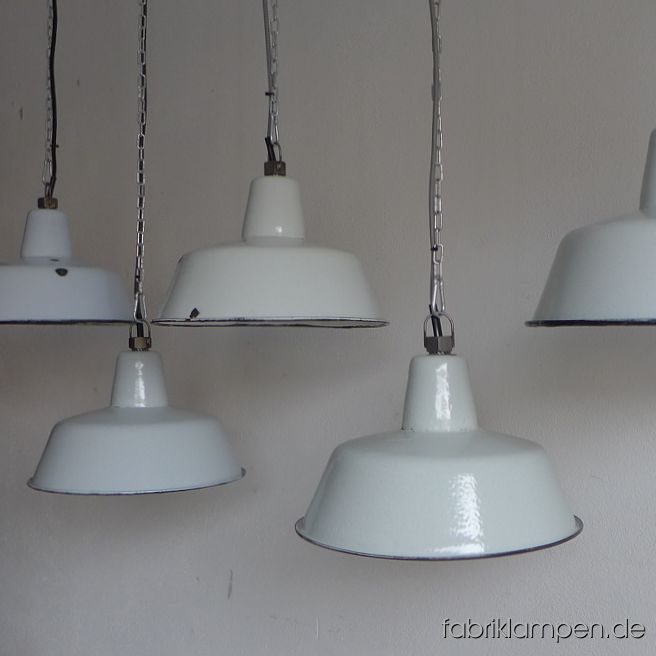 Seltene kleine hellgraue Fabriklampe mit Textilkabel. Material: hellgrau (innen weiß) emailliertes Stahlblech. Diese alten Industrielampen existieren in mehreren Farbtönen: neben hellgrau haben wir Lampen auch in verschiedenen Weißtönen (wie papyrusweiß, grauweiß) auf Lager. Für die Bilder haben wir bewusst Leuchten in verschieden Farbtönen ausgesucht. Für größere Bestellungen können wir farblich passende Leuchten aussuchen. 
Die Lampen haben die Spuren der vergangenen Jahrzehnte: Verfärbungen innen und außen, Abplatzer, Roststellen etc. Sie sind gereinigt, neu elektrifiziert und werden mit 2 Meter Textilkabel (in Farbe Ihrer Wahl) geliefert. 
Die alten Fabriklampen haben neue E27-Keramikfassungen und sind mit allen gängigen Leuchtmitteln einsetzbar (incl. LED- und Energiespar-Birnen). Die Lampen können auf Wunsch mit längerem Kabel oder mit Stahlrohr-Aufhängung und Baldachin ausgestattet werden (gegen Aufpreis). 
Die Abmessungen: Höhe ca. 21 cm, Durchmesser ca. 32 cm. 
Wir haben auch die größere Variante dieser Lampen auf Lager. 