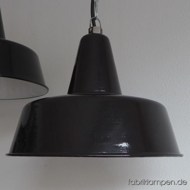 Alte schwarze Fabriklampen – eine mit Herstellermarke (die andere hat keine). Material: schwarz (innen weiß) emailliertes Stahlblech.
Diese alten Industrielampen haben die üblichen Spuren der vergangenen Jahrzehnte (Abplatzer, Roststellen, Kratzer, Verfärbungen und Co.). Sie sind gereinigt und neu elektrifiziert, mit E27 Keramikfassung. 
Die Fabriklampen werden mit Aufhängeöse und 2 Meter Kabel geliefert (andere Längen sind natürlich möglich), auf Wunsch können sie auch mit Textilkabel und Ketten- oder Stahlrohr-Aufhängung ausgestattet werden (gegen Aufpreis). 
Die Abmessungen: Durchmesser Lampe (Schirm) 40 cm, Höhe 28 cm. 
