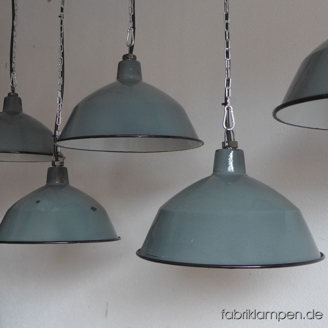 Alte, antike Fabriklampen in einem sehr schönen Farbton. Sie stammen aus den 1930ern Jahren, ein einmaliger Posten. Die Farbe ist ca. RAL 210 60 10, zementgrau mit einem Hauch resedagrün. Es kommt immer auf die Lichtverhältnisse an, wie die Farbe erscheint. Material: grau/grüngrau (innen weiß) emailliertes Stahlblech. Diese alten Industrielampen haben die üblichen Spuren der vergangenen Jahrzehnte (Abplatzer, Roststellen, Kratzer, Verfärbungen und Co.). Sie sind gereinigt und neu elektrifiziert, mit E27 Keramikfassung. Die Fabriklampen werden mit Aufhängeöse und 2 Meter Kabel geliefert (andere Längen sind natürlich möglich), auf Wunsch können sie auch mit Textilkabel und Ketten- oder Stahlrohr-Aufhängung ausgestattet werden (gegen Aufpreis). Die Abmessungen: Durchmesser Lampe (Schirm) 35 cm, Höhe 19 cm. 