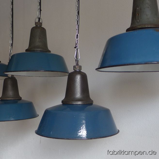 Sehr schöne alte blaue Fabriklampe mit gusseisernem Oberteil, teilweise mit Herstellermarke. Wir haben diese kleinen Lampen auch in anderen Farbtönen (mit grünen und grauen Emailleschirmen) auf Lager. Die Lampen haben die Spuren der vergangenen Jahrzehnte (manchmal ganz wenig, manchmal ausgeprägt: kleine Abplatzer, Roststellen, Kratzer, Verfärbungen and Co. – wir haben die alle behandelt), sie sind gereinigt und neu elektrifiziert, ausgestattet mit neuen E27 Keramikfassungen. Material: blau, grün, oder grau (innen weiß) emailliertes Blech, gusseisernes Oberteil. Sie bekommen die Lampen mit 2 Meter Kabel (andere Längen oder Textilkabel sind natürlich möglich) und massiven Aufhängeösen für die sichere Aufhängung. Gegen Aufpreis können die Lampen auch mit Ketten-Aufhängung oder Stahlrohr-Aufhängung und Baldachin geliefert werden. Die Abmessungen: Durchmesser Lampe (Schirm) 32 cm, Höhe 24 cm. 