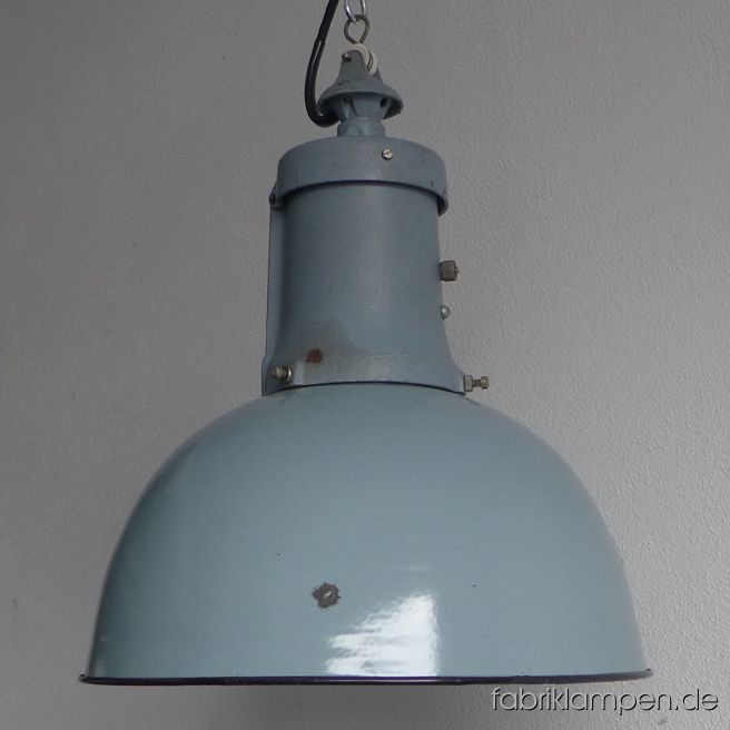 Alte hellgraue Industrielampe Emaille mit gusseisernem Oberteil, Nachkriegszeit, BRD. Die Lampe hat die Spuren der vergangenen Jahrzehnte (Abplatzer, Roststellen, Kratzer, Verfärbungen und Co. – wir haben die alle behandelt). Sie ist gereinigt und neu elektrifiziert, umgerüstet auf E27. Material: graublau emailliertes Stahlblech, gusseisernes Oberteil auch in graublau. Sie bekommen diese Lampe mit 2 Meter Textilkabel in Farbe Ihrer Wahl (andere Längen sind natürlich möglich). Gegen Aufpreis kann die Lampe auch mit Ketten-Aufhängung geliefert werden. Die Abmessungen: Durchmesser Lampe (Schirm) 40 cm, Höhe 47 cm. 