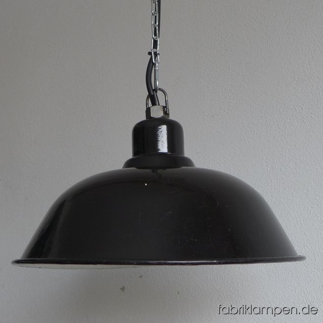 Schöne alte schwarze Fabriklampe aus den 1920-ern Jahren. Die Emailleleuchte ist gut erhalten, mit leichten Spuren der vergangenen Jahrzehnte (kleine Abplatzer, Roststellen, Kratzer, Verfärbungen und Co. – wir haben die alle behandelt). Die Lampe ist gereinigt und neu elektrifiziert, ausgestattet mit neuer E27 Keramikfassung. Material: schwarz (innen weiß) emailliertes Blech – die Innensteite bei der Fassung ist schwarz emailliert – sehr selten. 
Sie bekommen die Lampe mit 2 Meter Kabel (andere Längen oder Textilkabel sind natürlich möglich) und Aufhängeöse für die sichere Aufhängung. Gegen Aufpreis können die Lampen auch mit Ketten-Aufhängung oder Stahlrohr-Aufhängung und Baldachin geliefert werden. Die Abmessungen: Durchmesser Lampe (Schirm) 41 cm, Höhe 21 cm. 