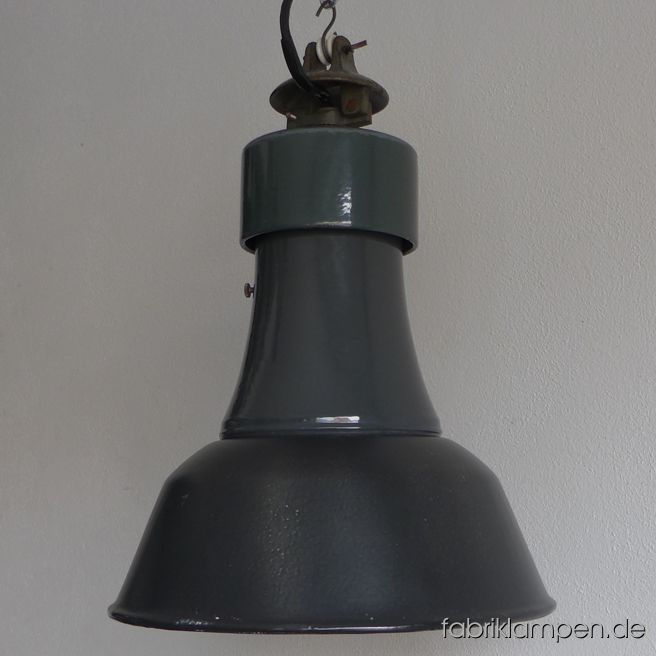 Antike graue Emaille Industrielampe mit dreiteiligem Aufbau, die Teile in verschiedenen Farbtönen. Sehr seltene klassische Form aus deutscher Herstellung. Die Lampe ist gut erhalten und hat kaum hat die Spuren der vergangenen Jahrzehnte. Sie ist gereinigt und neu elektrifiziert, umgerüstet auf E27. Material: in verschiedenen Grautönen (Oberteil dunkelgrün, innen weiß) emailliertes Stahlblech, Gusseisen. Sie bekommen diese Lampe mit 2 Meter Kabel und originaler Aufhängeöse für die sichere Aufhängung. Gegen Aufpreis kann die Lampe auch mit Ketten-Aufhängung geliefert werden. Die Abmessungen: Durchmesser Lampe (Schirm) 36 cm, Höhe 41 cm. 