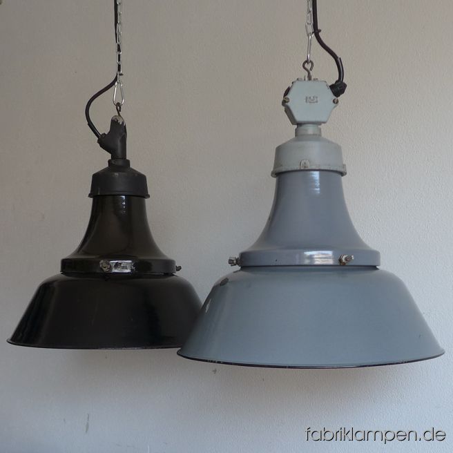 Alte antike Fabriklampen aus Emaille mit gusseisernem Oberteil, Deutschland, 1930-er Jahre. Die Lampen haben die Spuren der vergangenen Jahrzehnte (Abplatzer, Roststellen, Kratzer, Verfärbungen und Co. – wir haben die alle behandelt). Sie sind gereinigt und neu elektrifiziert, umgerüstet auf E27. Material: schwarz bzw. hellgrau emailliertes Stahlblech, gusseiserne Oberteile in schwarz bzw. in grau. Sie bekommen diese Lampen mit 2 Meter Textilkabel in Farbe Ihrer Wahl (andere Längen sind natürlich möglich). Gegen Aufpreis kann die Lampe auch mit Ketten-Aufhängung geliefert werden. Die Abmessungen: Durchmesser Lampe (Schirm) 41,5 cm, Höhe 44 cm. 
