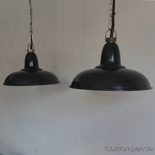 Alte, antike kleine Industrielampen mit Herstellermarke. Sie stammen aus den 1930-ern Jahren und sind für Ihr Alter gut erhalten. Kleine, zeitlos elegante Lampen mit schöner Form. Material: schwarz (innen weiß) emailliertes Stahlblech. Diese alten Industrielampen haben die üblichen Spuren der vergangenen Jahrzehnte (Abplatzer, Roststellen, Kratzer, Verfärbungen und Co.). Sie sind gereinigt und neu elektrifiziert, mit E27 Keramikfassung. Die Fabriklampen werden mit Aufhängeöse und 2 Meter Kabel geliefert (andere Längen sind natürlich möglich), auf Wunsch können sie auch mit Textilkabel und Ketten- oder Stahlrohr-Aufhängung ausgestattet werden (gegen Aufpreis). Die Abmessungen: Durchmesser Lampe (Schirm) 27 cm, Höhe 14,5 cm. 