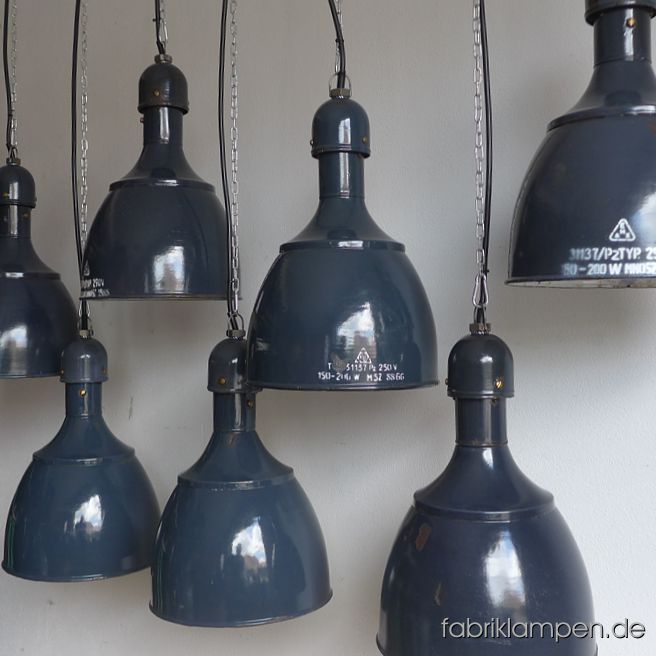 Sehr seltene alte Industrielampen mit Beschriftung / Herstellermarke. Diese emaillierten Fabriklampen haben eine sehr schöne, archaische und dennoch zeitlose, grazile und elegante Form. Die Lampen haben die starken Spuren der vergangenen Jahrzehnte (Abplatzer, Roststellen und Co. – wir haben die alle behandelt), sie sind gereinigt und neu elektrifiziert (mit E27 Keramikfassung). Material: graublau (innen weiss) emailliertes Stahlblech. Die Farbe der Aufschrift ist teilweise weiss, teilweise schwarz - letztere sind manchmal nur schwer zu erkennen. Bitte beachten Sie: Die Form ist sehr beliebt und wird heute in Osteuropa wieder hergestellt (und sogar als Original angeboten, sowohl in grün als auch in blau, weiss, schwarz, rostbraun etc.). In dem Fall der Replikate kann man sofort erkennen, um was es sich handelt. Die Lampen hier, wie alle unsere Lampen, sind natürlich Originale aus der Zeit. Die Abmessungen: Höhe der Lampen ca. 46 cm, Durchmesser ca. 31 cm. 