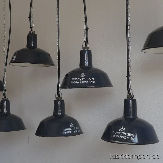 Alte kleine Fabriklampen mit weisser Aufschrift, selten. Material: grau-bläulich (innen weiss) emailliertes Blech. Die Lampen haben die (moderate) Spuren der vergangenen Jahrzehnte (wie Abplatzer, Roststellen, Kratzer, Verfärbungen und Co.), sie sind gereinigt und neu elektrifiziert. Sie haben E27-Fassungen und sind mit allen gängigen Leuchtmitteln einsetzbar (incl. LED- und Energiespar-Birnen). Die Abmessungen: Höhe ca. 18 cm, Durchmesser ca. 26 cm. Die Fabriklampen werden mit Aufhängeöse und 2 Meter Kabel geliefert (andere Längen sind natürlich möglich), auf Wunsch können sie auch mit Textilkabel und Ketten- oder Stahlrohr-Aufhängung ausgestattet werden (gegen Aufpreis). 