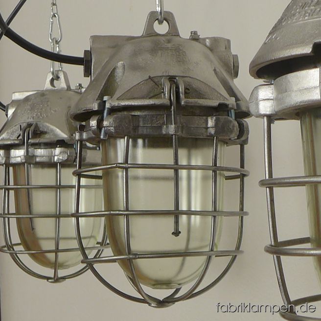Seltene kleine Bunkerlampe aus Aluminium mit Schutzglas und Gitter. Die Lampen sind aufgearbeitet, wir haben diesen Typ auch im Originalzustand auf Lager. Die Lampen sind gereinigt, aufgearbeitet (Gehäuse und Gitter geschliffen), konserviert und neu elektrifiziert. Material: Gehäuse aus Aluminium, Schutzgitter aus Stahl, Schutzglas (Thermoglas). Die Abmessungen: Höhe der Lampen ca. 35 cm, Durchmesser ca. 20 cm. Die Fabriklampen werden mit Aufhängeöse und 2 Meter Kabel geliefert (andere Längen sind natürlich möglich), auf Wunsch können sie mit Ketten-Aufhängung ausgestattet werden (gegen Aufpreis).