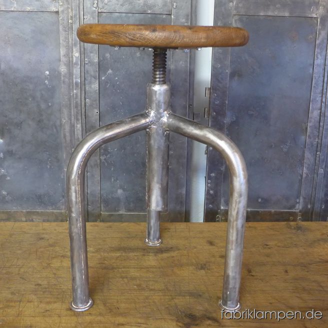 Alter Industriehocker (Drehhocker), höhenverstellbar, mit originalem Eichensitz. Das Gestell ist aufgearbeitet und konserviert, stellenweise mit Resten der Originalfarbe (weiss). Um ca. 1950. Einfache, minimalistische Form, massive Ausführung.  Der Sitz (gemacht aus einem Stück Eichenholz) ist mit Naturwachs behandelt. Die Sitzplatte ist 3,5 cm stark und hat eine angenehme Sitzmulde. Der Durchmesser des Sitzes beträgt 32 cm. Massive, unverwüstliche Ausführung, geeignet für Gastronomie oder Ihre Loft-Küche. Die Sitzhöhe erlaubt die Nutzung auch bei höheren Tischen/Theken als Barstuhl. Sitzhöhe von 48 bis 69 cm. 