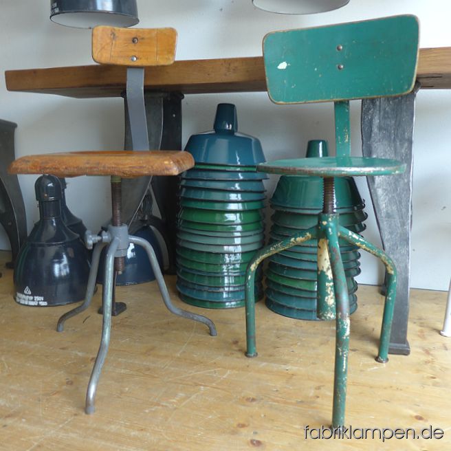 2 alte, höhenverstellbare Industriestühle (Drehstühle), einmal mit Eichensitz, einmal mit Metallsitz. Die Industriestühle sind schonend gereinigt und konserviert. Um ca. 1950-1960. Das graue Gestell des Stuhles mit Eichensitz besteht aus massivem Rundstahl, nicht aus Stahlrohr, der Stuhl ist daher recht massiv und gewichtig. Der Industriestuhl hat eine sehr schöne, interessante Form mit geschwungenen Linien. Mit dicker, rechteckiger Sitzplatte aus Eiche massiv, ebenso wie die Rückenlehne. Einfach unverwüstbar. Die Sitzplatte hat eine angenehme Sitzmulde. Der grüne Stuhl ist leicht aufgebaut, hat eine schöne Farbe und Patine. Ebenfalls konserviert. Massive, unverwüstliche Ausführung, geeignet für Gastronomie oder Ihre Loft-Küche. Die Sitzhöhe erlaubt die Nutzung auch bei höheren Tischen/Theken als Barstuhl.
 