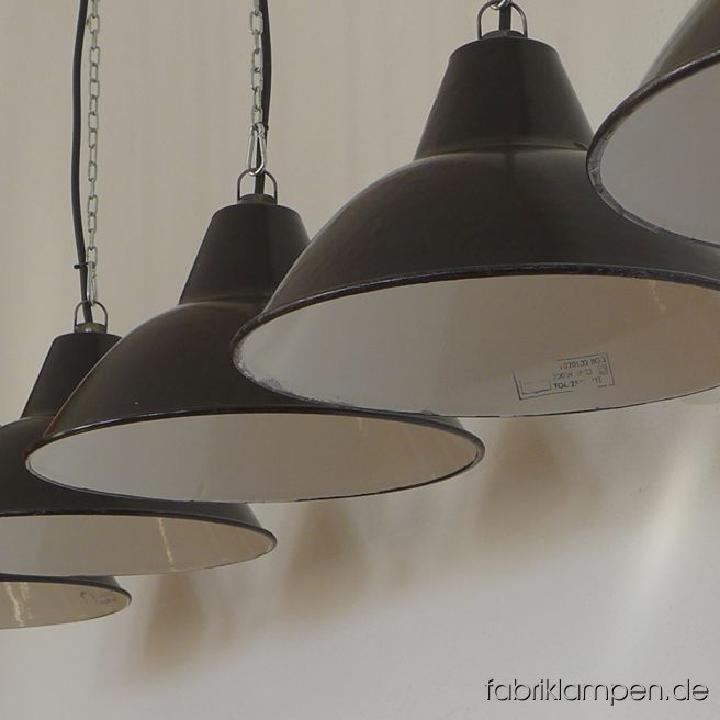 Alte schwarze Fabriklampen, Hersteller LBD (VEB Leuchtenbau Dresden). Die Lampen haben nur sehr moderate Spuren der vergangenen Jahrzehnte (kleine Abplatzer, Roststellen, Kratzer, Verfärbungen and Co. – wir haben die alle behandelt). Die Lampen sind fachgerecht gereinigt und neu elektrifiziert (E27 Keramikfassung). Material: schwarz (innen weiß) emailliertes Stahlblech. Höhe der Lampen ca. 21 cm (ohne Öse), Durchmesser ca. 38,5 cm. Wir haben auch die größere Variante auf Lager. Die Lampen werden mit Aufhängeöse und 2 Meter Kabel geliefert (andere Längen sind natürlich möglich), auf Wunsch können sie auch mit Textilkabel und Ketten- oder Stahlrohr-Aufhängung ausgestattet werden (gegen Aufpreis). 