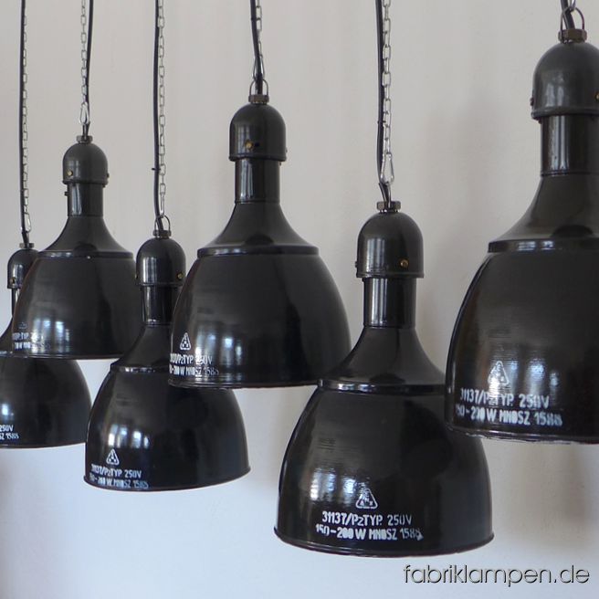Alte schwarze Industrielampen mit Beschriftung und Herstellermarke. Diese emaillierten Fabriklampen haben eine sehr schöne, archaische und dennoch zeitlose, grazile und elegante Form. Diese schönen Fabriklampen haben die üblichen Spuren der vergangenen Jahrzehnte (Abplatzer, Roststellen, Kratzer, Verfärbungen und Co.). Sie sind gereinigt und neu elektrifiziert, mit E27 Keramikfassung. Material: schwarz (innen weiss) emailliertes Stahlblech. Bitte beachten Sie: Die Form ist sehr beliebt und wird heute in Osteuropa wieder hergestellt (und sogar als Original angeboten, sowohl in grün als auch in blau, weiss, schwarz, rostbraun etc.). In dem Fall der Replikate kann man sofort erkennen, um was es sich handelt. Die Lampen hier, wie alle unsere Lampen, sind natürlich Originale aus der Zeit. Die Abmessungen: Höhe der Lampen ca. 46 cm, Durchmesser ca. 31 cm. Die Fabriklampen werden mit Aufhängeöse und 2 Meter Kabel geliefert (andere Längen sind natürlich möglich), auf Wunsch können sie auch mit Textilkabel und Ketten- oder Stahlrohr-Aufhängung ausgestattet werden (gegen Aufpreis). 