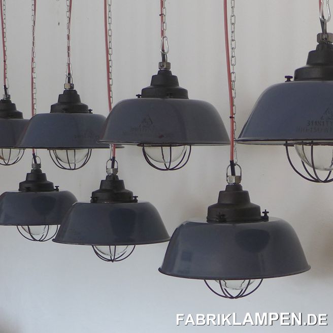 Alte blaue Fabriklampe mit gusseisernem Oberteil, Emailleschirm im seltenen blauen Farbton (Herstellermarke), Glas & Gitter. Ein einzigartiger Posten von gut erhaltenen Industrielampen aus einer alten Industriehalle. Die Fabriklampen haben nur minimale Spuren der vergangenen Jahrzehnte (Abplatzer, Roststellen, Kratzer, Verfärbungen und Co.). Sie sind gereinigt und neu elektrifiziert, mit neuen E27 Keramikfassungen. Material: dunkelblau emailliertes Stahlblech, gusseisernes Oberteil, Schutzglas und Stahlgitter. Sie bekommen die Lampen mit 2 Meter Kabel und massiven Aufhängeösen für die sichere Aufhängung. Gegen Aufpreis können die Lampen auch mit Ketten-Aufhängung geliefert werden. Die Abmessungen: Durchmesser Lampe (Schirm) 36 cm, Höhe 27 cm. 