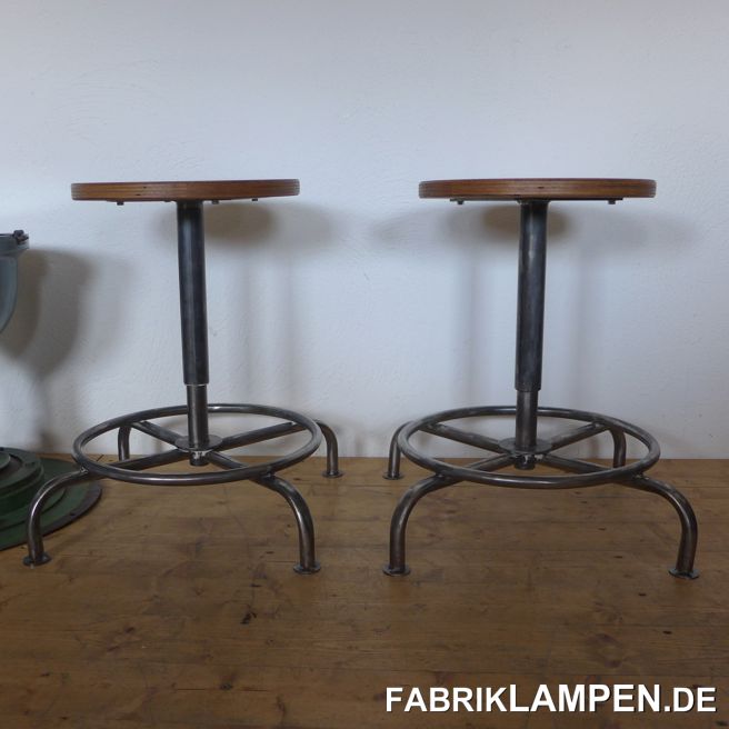 Alter Industriehocker, Werkstatthocker, höhenverstellbarer Drehhocker. Das Gestell ist aufgearbeitet und konserviert. 

Da die alten Sperrholzsitze nicht mehr zu verwenden waren, haben wir diese alten Hocker mit neuen Sperrholzsitzen montiert. Die Sitze sind mit Naturwachs behandelt. Die alten Fußkappen (Kunststoff) haben wir ebenfalls entfernt und durch kleine Fußplatten aus Stahl ersetzt (diese sind angeschweisst). 

Sehr schöne, interessante Form mit einer großen Fußablage. 

Massive, unverwüstliche Ausführung, geeignet für Gastronomie oder Ihre Loft-Küche (oder als Gitarrenhocker). Die Sitzhöhe erlaubt die Nutzung auch bei höheren Tischen/Theken als Barstuhl. 

Das Gewinde ist versteckt/geschützt. Die Spindel & das Gewinde sind im guten Zustand. 

Sitzhöhe von 45 bis 58 cm. Durchmesser Sitzplatte 35 cm. 