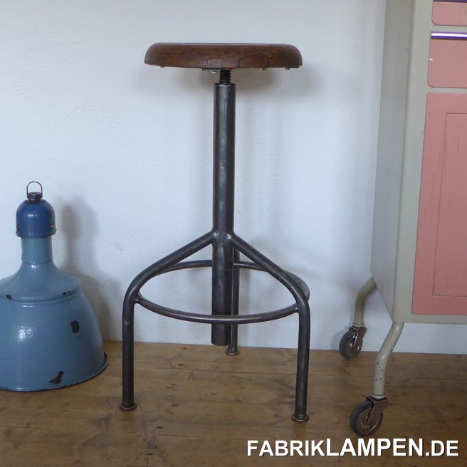 Alter Werkstatthocker, höhenverstellbarer Drehhocker, Industriehocker, Dreibein, mit altem Sitz (Hartholz). Der Hocker ist enorm robust und hoch – sehr seltene Form. 

Das Gestell ist aufgearbeitet und konserviert. Alte Sitzplatte aus Hartholz, mit schöner Patina und Gebrauchsspuren – wir haben sie mit Naturwachs behandelt. 

Sehr massive Form mit drei Füßen und runder Fußablage. 

Starke, unverwüstliche Ausführung, geeignet für Gastronomie oder Ihre Loft-Küche. Die Sitzhöhe erlaubt die Nutzung auch bei höheren Tischen/Theken als Barstuhl. 

Die Spindel & das Gewinde sind im guten Zustand. 

Sitzhöhe von 76 bis 100 (!) cm. Durchmesser Sitzplatte 34 cm. 