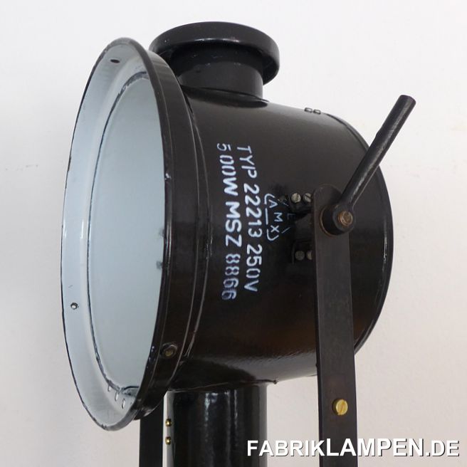 Alter Scheinwerfer mit Holzstativ (Dreibein, Tripod). Diese alte Industrielampe hat die Spuren der vergangenen Jahrzehnte (Kratzer, Abplatzer, Roststellen, Verfärbungen and Co.). Sie ist restauriert: gereinigt und konserviert, das Innenleben der Lampe ist neu. 

Neu elektrifiziert, mit E27 Keramikfassung. Die alte Lampe kann mit allen gängigen E27-Leuchtmitteln benutzt werden (unsere Empfehlung sind die LED-Birnen). Ausgestattet mit 4 Meter Kabel und Schuko-Stecker mit Schalter.

Das alte höhenverstellbare Holzstativ ist gereinigt und gewachst. Wir haben weitere Scheinwerfer von diesem Typ (auch für die Wand- oder Deckenmontage oder als Bodenlampe) auf Lager.

Material: schwarz/anthrazit (innen weiss) emailliertes Stahlblech (mit Herstellerangaben), Holzstativ (Hartholz). 

Die Abmessungen: Durchmesser Scheinwerfer am Rand ca. 31 cm, Höhe Emaillelampe 45 cm, Höhe Lampe mit Bügel 60 cm, Gesamthöhe wie abgebildet ca. 203 cm.  