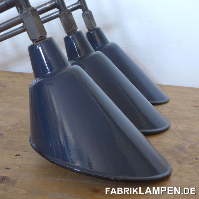 Wandlampe, Emaille: Ausleger mit alten, originalen Fabriklampen. Die seltenen asymmetrischen Schirme sind selbstverständlich alt, mit demenstprechenden Alters- und Gebrauchsspuren, wie Abplatzer, Roststellen, Kratzer, Verfärbungen. Alles ist, wie immer, gereinigt und konserviert. Die Ausleger sind auf Kundenwunsch aus Stahlrorh gefertigt und gewachst (nachdem sie eine leichte Patina bekommen haben). 

Diese Wandlampen, wie alle unsere Lampen, sind neu elektrifiziert, ausgestattet mit E27 Porzellanfassung und damit mit allen handelsüblichen E27 Leuchtmitteln, wie klassische Glühbirnen, Energiespar-, LED-, Halogen- und Retro-Birnen, einsetzbar. Die Ausleger haben am Wand eine große, praktische Dose, die die Installation erheblich erleichtert. Ihre Elektriker werden genug Platz für die Elektroinstallation (und das Kabel zu verstecken) haben und dank breiter Flügel müssen die Dübel nicht eng neben dem Kabel im Wand befestigt werden. 

Wir empfehlen diese Wandlampen für größere Räume. 

Wichtig: die Lampen sind ausschließlich für den Innerbereich geeignet. 

Unsere Ausleger können mit ca. 60-70 verschiedenen Typen (Form/Größe/Farbe) von alten Fabriklampen ausgestattet werden. Hier finden Sie einige Beispiele dafür. Der Durchmesser der Schirme liegt zwischen 30 und 46 cm, sowohl einfache Fabriklampen als auch Bunkerlampen mit Gusseisernem Oberteilen und Glas & Gitter etc. können montiert werden. Größere Serien mit Dutzenden von identischen Leuchten sind auch möglich, sprechen Sie uns einfach an! 

Abmessungen: Länge/Tiefe (von der Wand bis Unterkante Schirm) ca. 85 cm, Gesamthöhe bis Unterkante Schirm (inkl. Wandarm) ca. 60 cm, Breite (Schirm) ca. 24,50 cm. 