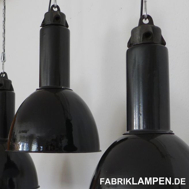Alte schwarze Industrielampe mit gusseisernem Oberteil. 

Diese schönen Fabriklampen haben die üblichen Spuren der vergangenen Jahrzehnte (Abplatzer, Roststellen, Kratzer, Verfärbungen und Co.). Sie sind restauriert: gereinigt und konserviert, neu elektrifiziert, mit Adapter auf E27.

Material: schwarz (innen weiss) emailliertes Stahlblech, Gusseisen. 

Die Abmessungen: Höhe der Lampen ca. 46 cm, Durchmesser ca. 31 cm. 

Auch die größere Ausführung steht zur Verfügung: Gesamthöhe: ca. 53,5 cm, Durchmesser Schirm ca. 35 cm.

Die Fabriklampen werden mit 2 Meter Kabel geliefert (andere Längen sind natürlich möglich), auf Wunsch können sie auch mit Textilkabel und Ketten- oder Stahlrohr-Aufhängung ausgestattet werden (gegen Aufpreis). 
 