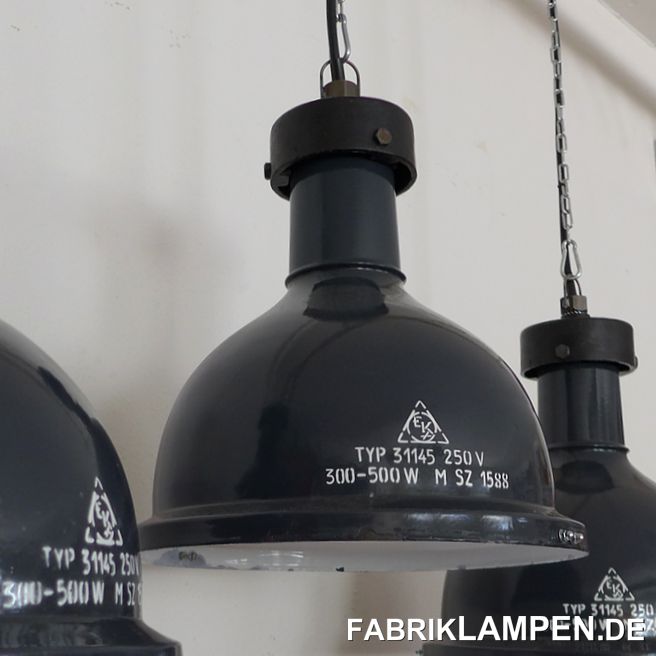 Alte Fabriklampe, gusseisenes Oberteil, graublaue Emaille. Klassische dreiteilige Ausführung, mit gusseisernem Kopf. Sehr seltene Form, man hat diese Lampen früher auf alten Krananlagen verwendet.  

Diese schönen Fabriklampen haben die üblichen Spuren der vergangenen Jahrzehnte (Abplatzer, Roststellen, Kratzer, Verfärbungen und Co.). Sie sind restauriert: gereinigt und konserviert, neu elektrifiziert, mit neuen Keramikfassungen E27.

Material: graublau (innen weiss) emailliertes Stahlblech, Gusseisen. 

Die Abmessungen: Höhe der Lampen ca. 39 cm (ohne Öse), Durchmesser ca. 36 cm. Gewicht ca. 4,5 Kg. 

Die Fabriklampen werden mit 2 Meter Kabel geliefert (andere Längen sind natürlich möglich), auf Wunsch können sie auch mit Textilkabel und Ketten- oder Stahlrohr-Aufhängung ausgestattet werden (gegen Aufpreis).
 