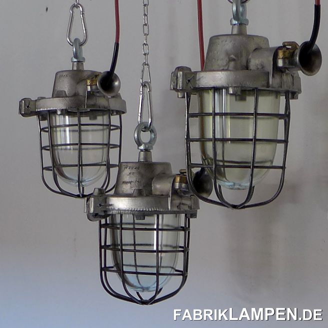 Alte Industrielampe aus Aluminium mit Schutzglas und Gitter. Die Lampen sind aufgearbeitet.

Die Lampen sind gereinigt, aufgearbeitet (Gehäuse und Gitter geschliffen), konserviert und neu elektrifiziert (mit neuen E27 Keramikfassungen). Material: Gehäuse aus Aluminium, Schutzgitter aus Stahl, Schutzglas (Thermoglas). Das Klemmteil am Ohr ist aus Messing, was eher selten ist und der Lampen eine besondere Charme verleiht.  

Die Abmessungen: Höhe der Lampen (ohne Aufhängeöse) 30 cm, Durchmesser Gehäuse (ohne „Ohr“) ca. 20 cm.

Die alten Fabriklampen werden mit Aufhängeöse und 2 Meter Kabel geliefert (andere Längen sind natürlich möglich), auf Wunsch können sie mit Ketten-Aufhängung ausgestattet werden (gegen Aufpreis). 