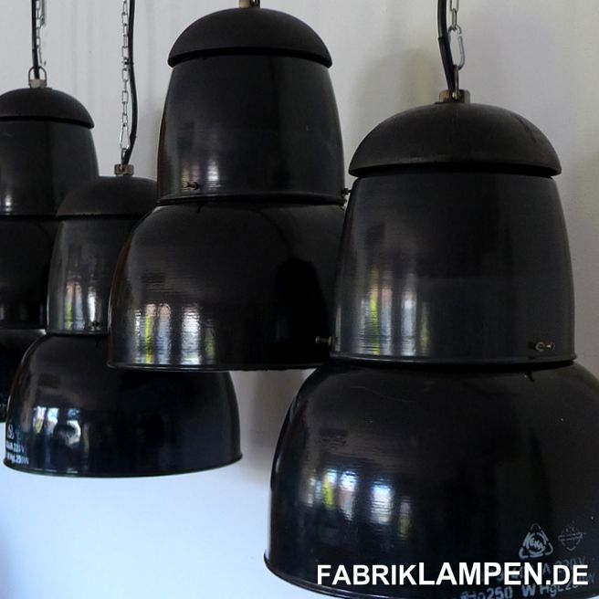 Alte schwarze Industrielampen, Fabriklampen mit gusseisernem Oberteil. Alter: ab 1948 bis Ende der 1950er Jahre. 

Die Industrielampen haben geringe Spuren der vergangenen Jahrzehnte (Abplatzer, Roststellen, Kratzer, Verfärbungen und Co.). Die Hälse sind tendenziell heller – die Farbe der mittleren Teile geht in Richtung anthrazit und ist nicht homogen. 

Sie sind gereinigt und neu elektrifiziert, mit neuen E27 Keramikfassungen.

Material: schwarz/anthrazit (innen weiss) emailliertes Stahlblech, Gusseisen. 

Sie bekommen die Lampen mit 2 Meter Kabel und massiven Aufhängeösen für die sichere Aufhängung. Gegen Aufpreis können die Lampen auch mit Textilkabel und Ketten-Aufhängung geliefert werden. Baldachine können wir auch anbieten. 

Die Abmessungen: Höhe der Lampen ca. 50 cm (ohne Öse), Durchmesser ca. 41 cm, Gewicht ca. 8 kg. 

Wir haben diese Lampen auch in graublau auf Lager. 