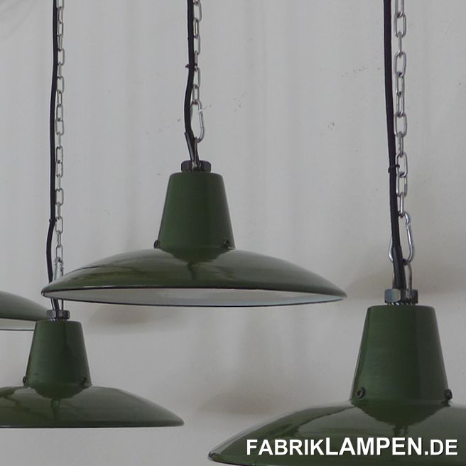 Grüne Fabriklampen, Emaille, alt, aus altem Lagerbestand. Perfekt erhaltene alte Lampen aus den 1950er Jahren. Da mit dem Begriff „alter Lagerbestand“ heutzutage wirklich viele Sachen bezeichnet werden, die mit der Bezeichnung alt schlicht nichts zu tun haben, haben wir einige Bilder über die Lampen im Fundzustand gemacht (letztes Bild in der Galerie). Die Lampen waren Teil eines größeren Fundes, der aus dieser Zeit enorm selten ist. Details dazu finden Sie hier. Da in diesem Posten auch Schirme von Louis Poulsen in zwei Abmessungen und in größeren Anzahl vorkamen, ist es nicht auszuschließen, dass auch diese Schirme aus dem Hause Louis Poulsen stammen könnten. 

Die Lampen haben eine schnörkellose, sehr klare und minimalistische Form der 1950-er Jahre. 

Diese alten Industrielampen waren nie im Gebrauch und daher in einem sehr guten Zustand. Hier und da haben sie - einfach wegen des Alters - geringe Spuren der vergangenen Jahrzehnte (kleine Abplatzer, Roststellen, Kratzer, Verfärbungen und Co.). 

Sie sind gereinigt und neu elektrifiziert, mit neuen E27 Keramikfassungen.

Material: grün (innen weiß) emailliertes Stahlblech. Unten am Hals sind 3 Löcher mit Gewinde, vermutlich für die Befestigung eines Glases. Die meisten Emaille Industrielampen, die auch mit Glas eigesetzt werden können, waren ohne Glas im Gebrauch, auch bei diesen Schirmen gibt es kein Glas. 

Sie bekommen die Lampen mit 2 Meter Textilkabel in Farbe Ihrer Wahl und massiver Aufhängeöse für die sichere Aufhängung. Gegen Aufpreis können die Lampen auch mit Ketten- oder Stahlrohr-Aufhängung geliefert werden. Baldachine können wir auch anbieten. 

Die Abmessungen: Höhe der Lampen ca. 14 cm (ohne Öse), Durchmesser ca. 34,5 cm. 