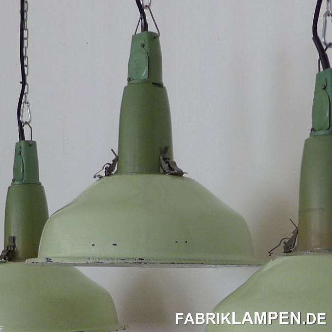 Alte Industrielampe in grün, Schirm Emaille, mit Aluminium Oberteil. 

Die Lampen haben die deutlichen Spuren der vergangenen Jahrzehnte (kleine Abplatzer, Roststellen, Kratzer, Verfärbungen und Co. – wir haben die alle behandelt). Sie sind restauriert: gereinigt und konserviert. Die alten Fabriklampen sind, wie neu elektrifiziert, ausgestattet mit neuen E27 Keramikfassungen. Das komplette Innenleben der Lampen ist neu. 

Material: außen grün (die Farbe des Schirms kann als weißgrün bezeichnet werden), innen weiß emailliertes Stahlblech, Aluminium Gehäuse. 

Sie bekommen die Lampen mit 2 Meter Kabel (andere Längen oder Textilkabel sind natürlich möglich) und massiven Aufhängeösen für die sichere Aufhängung. Gegen Aufpreis können die Lampen auch mit Ketten-Aufhängung und Baldachin geliefert werden. 

Die Abmessungen: Durchmesser Lampe (Schirm) 41 cm, Höhe der Lampe 41 cm. 