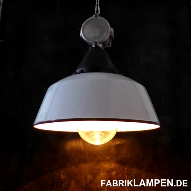 Weiße Fabriklampe Emaille alt, mit gusseisernem Oberteil, Aluminium Verteilerdose und Schutzglas. 

Die Lampen haben die Spuren der vergangenen Jahrzehnte (kleine Abplatzer, Roststellen, Kratzer, Verfärbungen und Co. – wir haben die alle behandelt), sie sind restauriert: gereinigt und konserviert, die Oberteile (Gusseisen Gehäuse und Aluminium Verteilerdose) sind aufgearbeitet. Die alten Fabriklampen sind, wie neu elektrifiziert, ausgestattet mit neuen E27 Keramikfassungen. Das komplette Innenleben der Lampen ist neu. 

Material: weiß emailliertes Stahlblech (meist mit Herstellermarke), gusseisernes Gehäuse, Aluminium Verteilerdose, Schutzglas. 

Sie bekommen die Lampen mit 2 Meter Kabel (andere Längen oder Textilkabel sind natürlich möglich) und massiven Aufhängeösen für die sichere Aufhängung. Gegen Aufpreis können die Lampen auch mit Ketten-Aufhängung und Baldachin geliefert werden. 

Die Abmessungen: Durchmesser Lampe (Schirm) 41 cm, Höhe der Lampe 28 cm, Gesamthöhe mit Verteilerdose und Glas 41,5 cm. 
