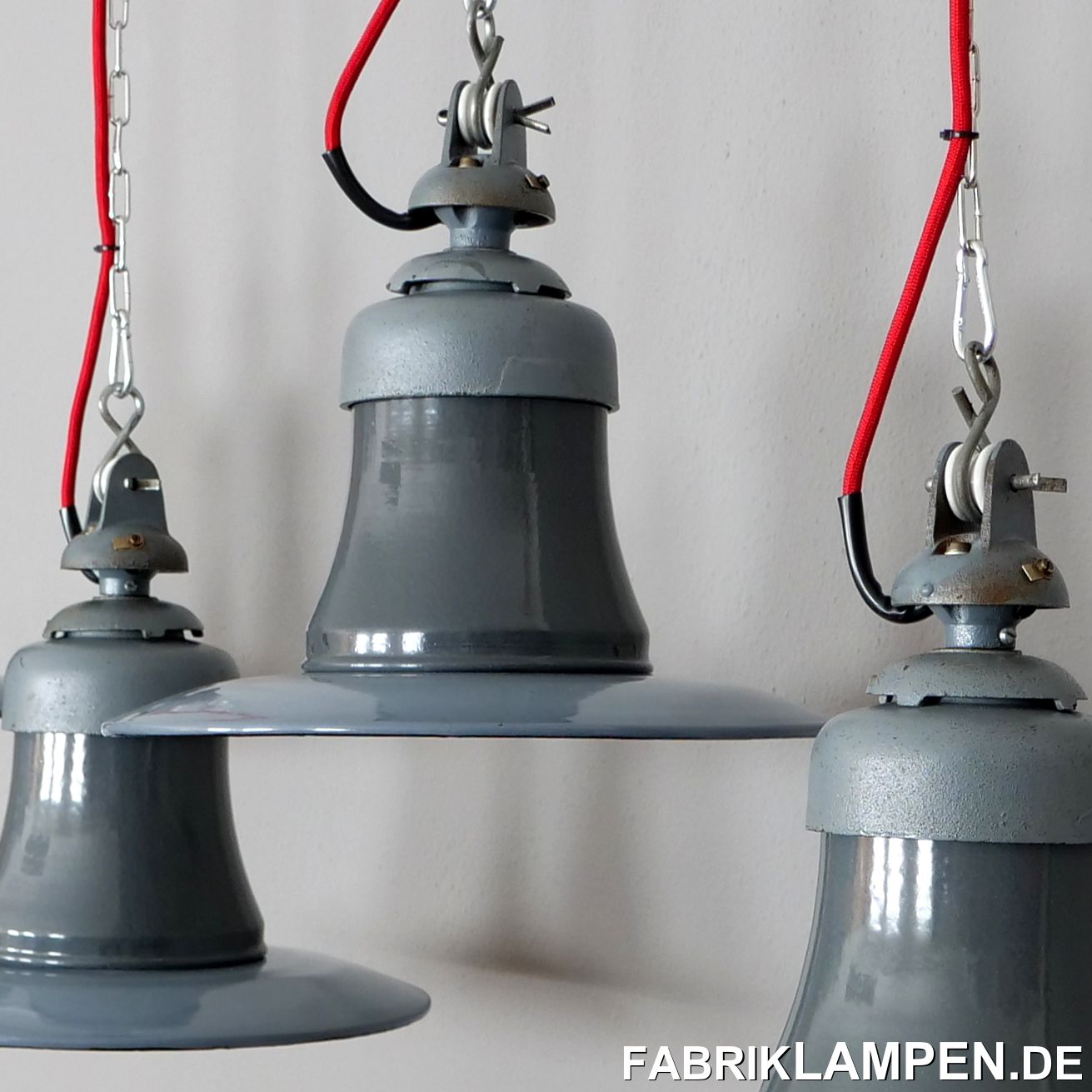  Alte Industrielampen, Fabriklampen mit gusseisernem Oberteil aus dem Hause Siemens. Wir haben vor Kurzem diese Lampen aus einer alten Halle in Hessen gekauft. Die Lampen waren bis zur letzten Minute in der geheizten Halle im Dienst und dementsprechend sind sie für den Alter sehr gut erhalten. Auch die originalen Aufhängungen mit den Porzellanrollen sind vorhanden. Diese Lampen in der Regel unter rauen Bedingungen im Einsatz und haben massive Gebrauchsspuren – solche Exemplare haben wir auch aus einem anderen Fundort, wenn es für Ihr Projekt nötig wäre. 

Die Industrielampen haben sehr geringe Spuren der vergangenen Jahrzehnte (Abplatzer, Roststellen, Kratzer, Verfärbungen und Co.), in erster Linie unten an den Schrauben. Die Schirme sind heller, die Hälse dunkler – Lampen mit Teilen in gewollt unterschiedlichen Farben sind typisch für die damalige deutsche Herstellung. 

Sie sind restauriert: gereinigt, konserviert und neu elektrifiziert, mit neuen E27 Keramikfassungen.

Material: hellblau/grau (innen weiß) und grau emailliertes Stahlblech, Gusseisen.
Die alten Industrielampen werden mit 2 Meter Textilkabel Farbe Ihrer Wahl (andere Längen sind natürlich möglich) und massiver Aufhängeöse für die sichere Aufhängung geliefert. Gegen Aufpreis können die Lampen auch mit Ketten- oder Stahlrohr-Aufhängung geliefert werden. Baldachine können wir auch anbieten.

Die Abmessungen: Höhe der Lampen ca. 30 cm (mit Aufhängung), Durchmesser ca. 35 cm, Gewicht ca. 3 kg.

Wir haben diese Lampen auch im Durchmesser 41 cm auf Lager (mit zwei Fassungen), manche auch mit Gläser – für Preise und weitere Details sprechen Sie uns an!  
