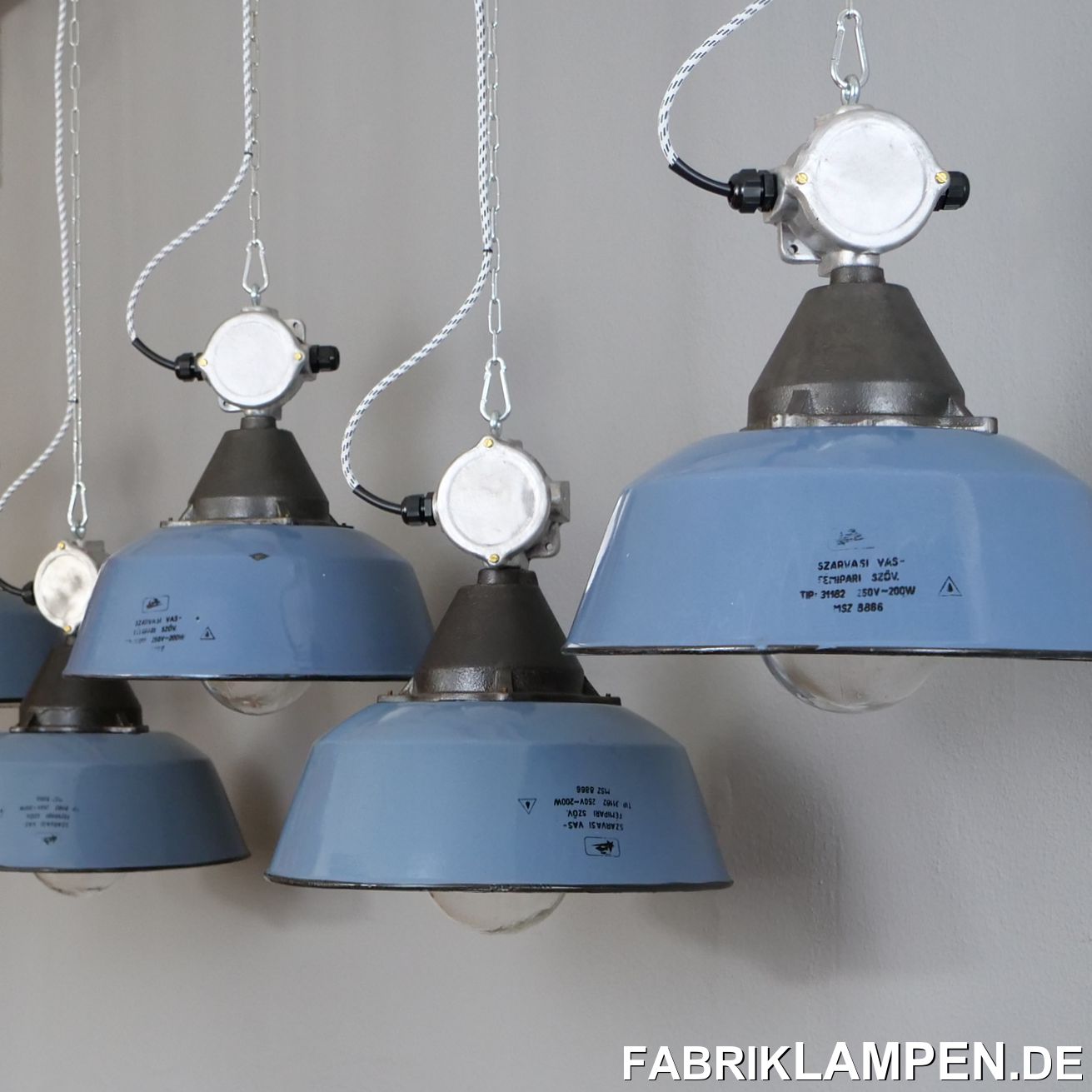  Alte Industrielampe mit gusseisernem Oberteil, Aluminium Verteilerdose, Emailleschirm in einem blauen Farbton (mit Herstellermarke) und Schutzglas. Wir haben diese Emaillelampen auch in anderen Blautönen und in weiß auf Lager. 

Gut erhaltene alte Fabriklampen aus einer ehemaligen Industriehalle. Die Emailschirme der alten Industrielampen haben die üblichen Spuren der vergangenen Jahrzehnte (Abplatzer, Roststellen, Kratzer, Verfärbungen und Co.). Die Metallteile (Verteilerdose und Gehäuse) sind aufgearbeitet, das gusseiserne Gehäuse anschließend konserviert. Die Fabriklampen sind neu elektrifiziert, mit neuen E27 Keramikfassungen, das komplette Innenleben ist neu.

Material: blau (graublau) emailliertes Stahlblech, Aluminium Verteilerdose, gusseisernes Oberteil, Schutzglas.

Ihre alte Industrielampe wird mit 2 Meter Textilkabel in Farbe Ihrer Wahl (andere Längen sind natürlich möglich) und massiver Aufhängeöse für die sichere Aufhängung geliefert. Gegen Aufpreis können die Fabriklampen auch mit Ketten- oder Stahlrohr-Aufhängung geliefert werden. Baldachine können wir auch anbieten.

Die Abmessungen: Durchmesser Lampe (Schirm) 41 cm, Höhe der Lampe 28 cm, Gesamthöhe mit Verteilerdose und Glas 41,5 cm.

Wir haben diese Lampen sowohl in weiß als auch im Durchmesser 36 cm auf Lager – für Preise und weitere Details sprechen Sie uns an!  