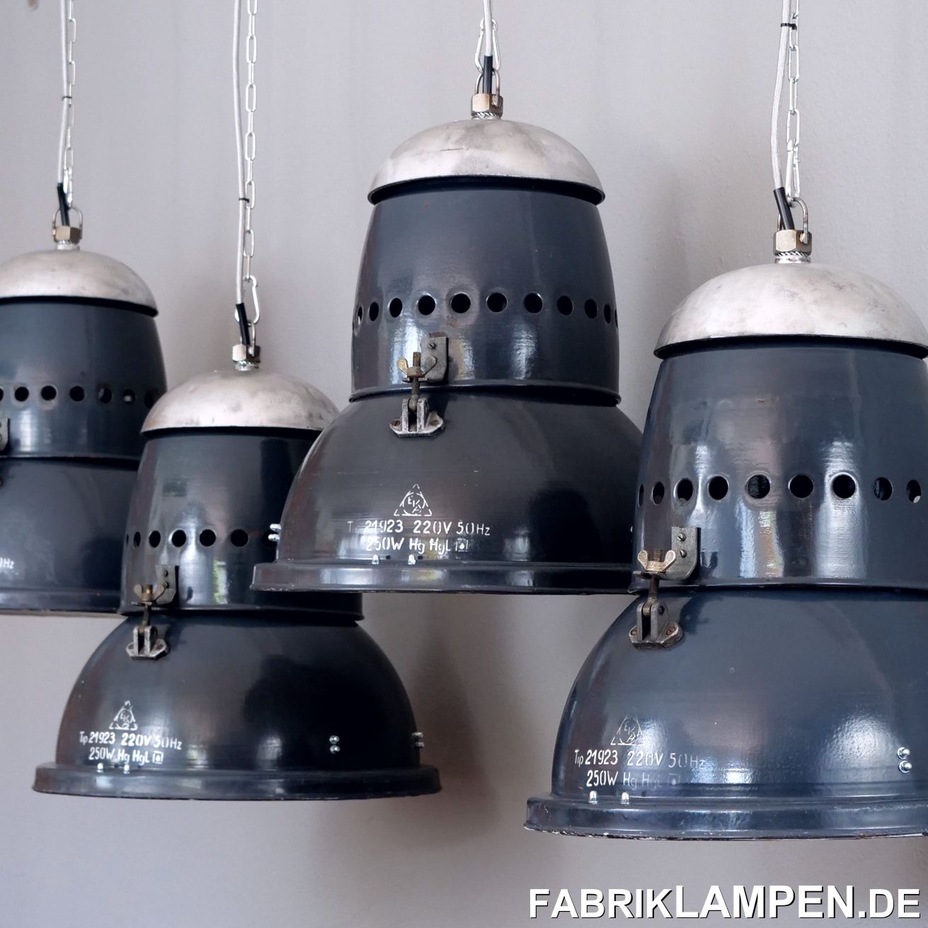  Alte graublaue Fabriklampen mit Aluminium Kopfteil und gelochtem Hals. Sehr charakteristischer Aufbau, mit vielen Schrauben – Industriedesign pur. 

Die alten Industrielampen haben die Spuren der vergangenen Jahrzehnte (Verfärbungen, kleine Abplatzer, Roststellen and Co. – wir haben die alle behandelt). Die Kopfteile sind aufgearbeitet worden. Die alten Fabriklampen sind neu elektrifiziert, mit neuen E27 Keramikfassungen, das komplette Innenleben ist neu.

Material: graublau (innen weiß) emailliertes Stahlblech (mit Herstellermarke), Aluminium Deckel. 

Die Form ist kompakt, sie wirkt nicht robust, kann universal eingesetzt werden – diese Fabriklampen sind sowohl für größere Räume (Gastronomie) als auch für Wohnbereiche (über Tisch, Kücheninsel, Theke etc.) geeignet. Der ultimative Eye-Catcher. 

Ihre alte Industrielampe wird mit 2 Meter Textilkabel in Farbe Ihrer Wahl (andere Längen sind natürlich möglich) und massiver Aufhängeöse für die sichere Aufhängung geliefert. Gegen Aufpreis können die Fabriklampen auch mit Ketten- oder Stahlrohr-Aufhängung geliefert werden. Baldachine können wir auch anbieten.

Die Abmessungen: Durchmesser Lampe (Schirm) 44,5 cm, Höhe 44 cm.  