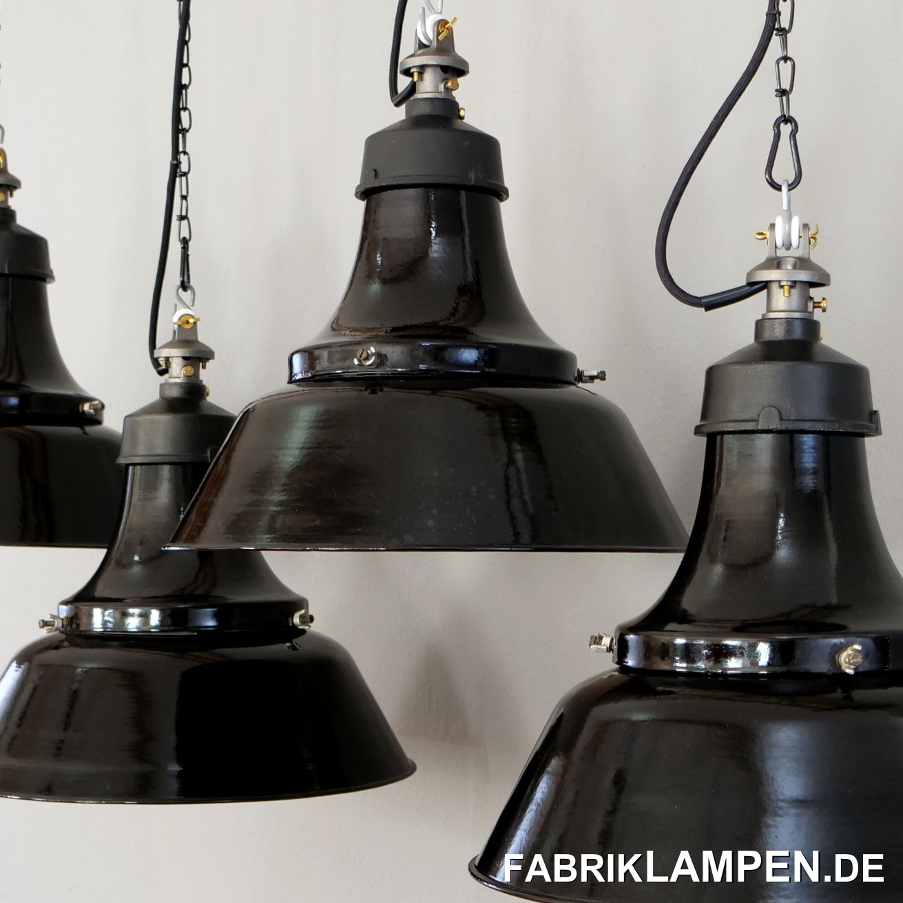  Alte schwarze Industrielampe, Fabriklampe mit gusseisernem Oberteil aus den 1930-er Jahren. Provenienz: BMW-Werk München. Die Lampen stammen aus deutscher Herstellung und hingen in einem alten Werksgebäude in München bis zum dessen Abriss. Sie waren ordentlich verschmutzt, unter der Staubschicht waren die Schirme allerdings besten erhalten.  

Die Fabriklampen waren in der Regel unter rauen Bedingungen im Einsatz und haben massive Gebrauchsspuren, dieser Posten ist ungewöhnlich schön erhalten.

Die alten Industrielampen haben sehr geringe Gebrauchsspuren der vergangenen Jahrzehnte (Abplatzer, Roststellen, Kratzer, Verfärbungen und Co.), in erster Linie unten an den Schrauben. 
Die alten Fabriklampen sind restauriert: gereinigt, konserviert und neu elektrifiziert, mit neuen E27 Keramikfassungen.

Material: schwarz (innen weiß) emailliertes Stahlblech, Gusseisen Top, Stahlguss Aufhängung.

Ihre alte Industrielampe wird mit 2 Meter Textilkabel Farbe Ihrer Wahl (andere Längen sind natürlich möglich) und massiver Aufhängeöse für die sichere Aufhängung geliefert. Gegen Aufpreis können die Industrielampen auch mit Ketten- oder Stahlrohr-Aufhängung geliefert werden. Baldachine können wir auch anbieten.

Alte Industrielampe, die Abmessungen: Höhe der Lampen ca. 34 cm (40 cm mit Aufhängung), Durchmesser Lampe (Schirm) ca. 41 cm, Gewicht ca. 3 kg.  