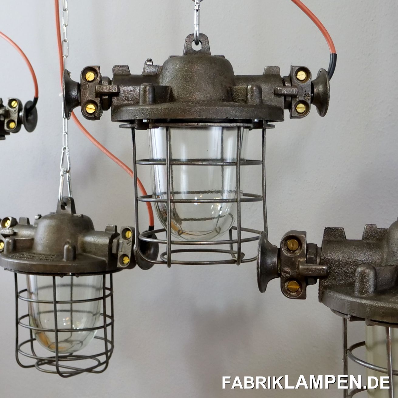  Alte Industrielampe, Bunkerlampe aus Stahlguss mit Schutzglas und Gitter. Die Fabriklampen sind aufgearbeitet. Diese alten Fabriklampen sind sehr robust in dem Aufbau und der Form. Die massiven seitlichen Kabelführungen unterstreichen den starken industriellen Charakter. 

Die Bunkerlampen sind gereinigt, aufgearbeitet (Gehäuse und Gitter geschliffen), konserviert und neu elektrifiziert (mit neuen E27 Keramikfassungen). Material: Gehäuse aus Stahlguss, Schutzgitter aus Stahl, Schutzglas (Thermoglas).

Die Abmessungen: Höhe der Lampen (mit der Aufhängeöse) 31 cm, Durchmesser Gehäuse (ohne Kabelführungen) ca. 23 cm, Gesamtbreite mit den „Ohren“ ca. 36 cm.

Achtung: das Gewicht der alten Industrielampe beträgt stolze 9,5 Kg – die Lampen brauchen eine tragfähige Deckenkonstruktion und massive Ketten zur Aufhängung. 

Die alten Fabriklampen werden mit Aufhängeöse und 2 Meter Kabel geliefert (andere Längen sind natürlich möglich), auf Wunsch können sie mit Ketten-Aufhängung ausgestattet werden (gegen Aufpreis). 